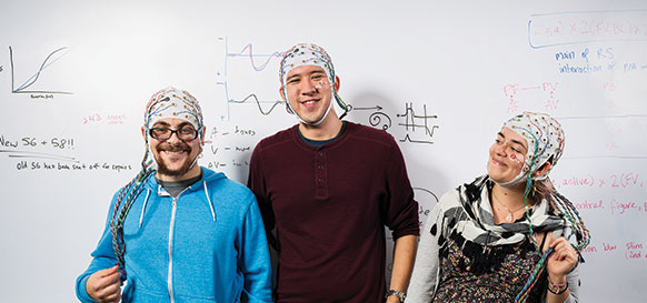 Orestis Papaioannou ’15, Chris Graulty ’15, and Phoebe Bauer ’15 probe the brain’s ability to extract visual information from the auditory channel in Reed’s SCALP Lab. Photo by Clayton Cotterell.