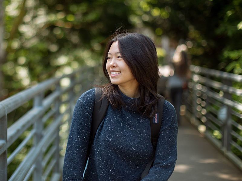 A student smiles while walking over the Blue Bridge in the Reed canyon.
