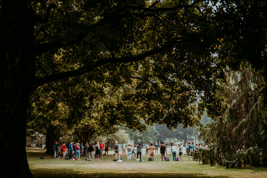 A group of students are seen from a distance standing in a circle.