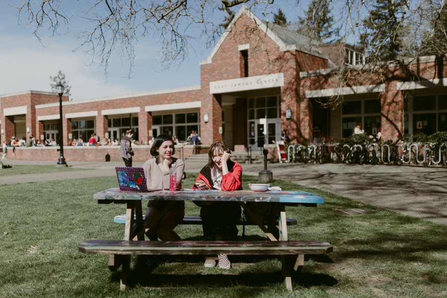 Reed students sitting at an outdoor picnic table.