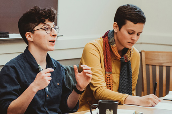 Two Reed students discussing in a classroom.