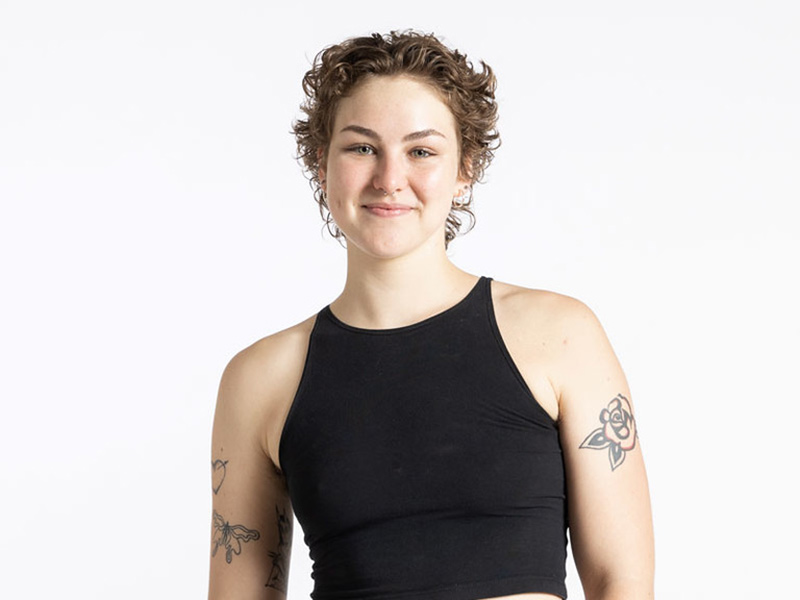 A portrait photo of Olivia McGough, who poses in a black tank top and black pants