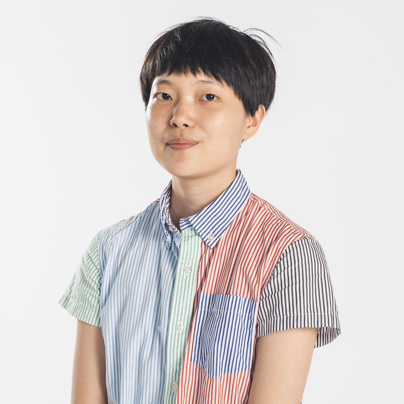 A portrait photo of Hoyong "Jodie" Moon, who is wearing a multicolored striped button-down shirt
