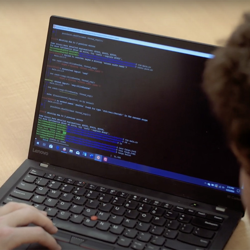 An open laptop shows coding on  the screen