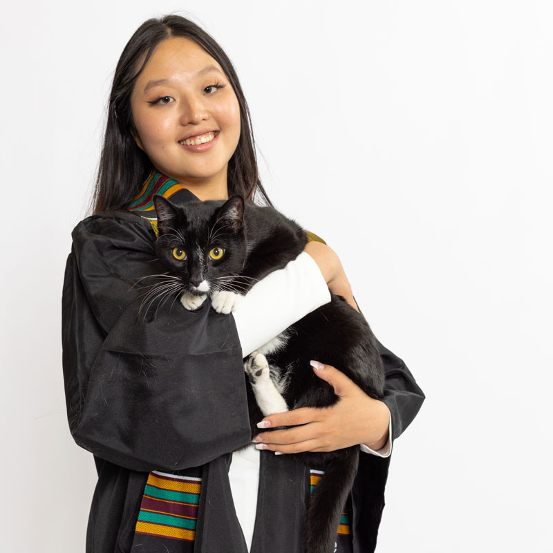 A portrait photo of Sherry Xinyue Chiang, who is holding a black cat in her arms