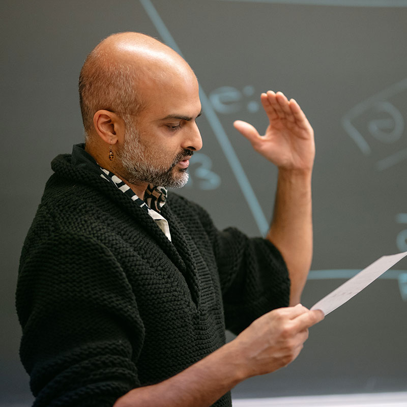 Sameer ud Dowla Khan, professor of linguistics, speaks in a classroom.