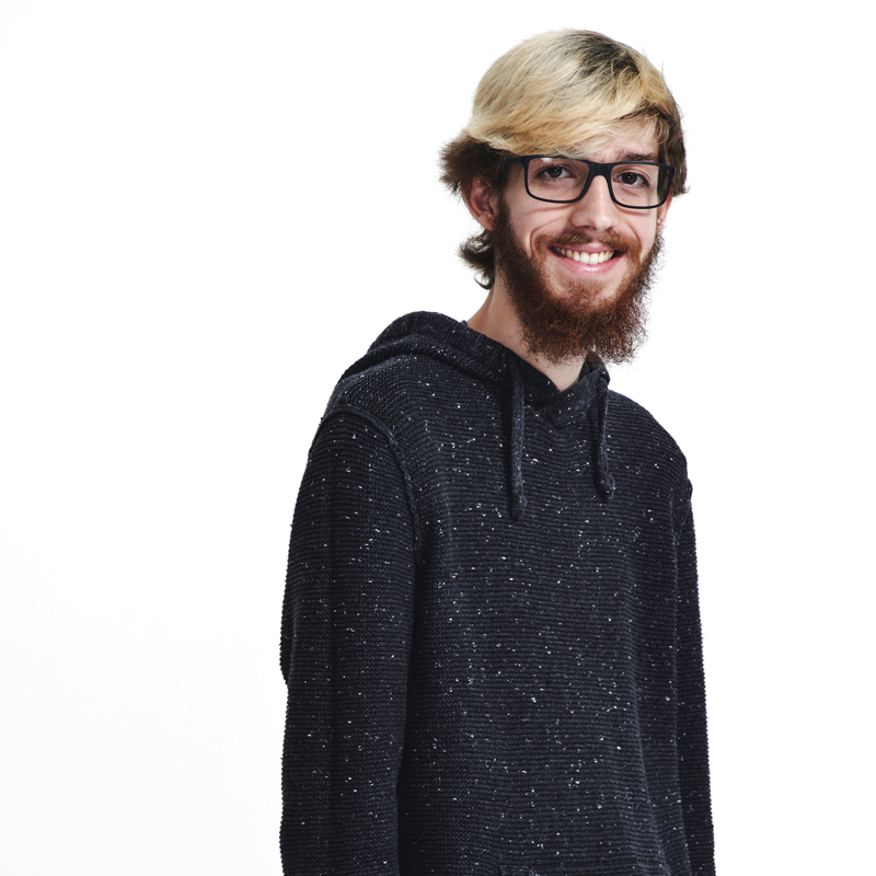 A portrait photo of Beckett Cummings, who is wearing a black hoodie with white speckles on it