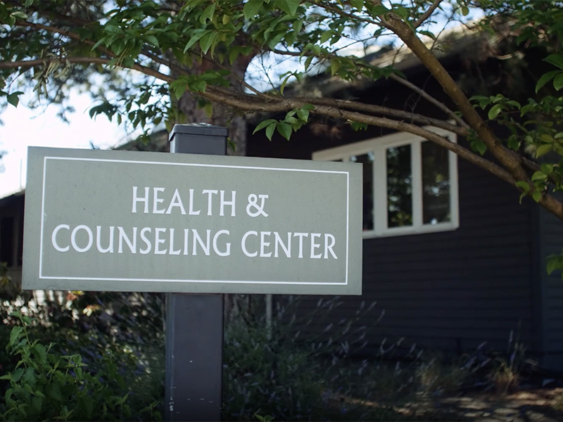 The waiting area of the Health and Counseling Center has a check-in counter, chairs, and tables with hand sanitizer