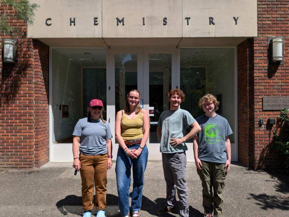 Four members of the Gratz Lab posing in front of the chemistry building