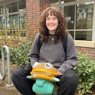 Sierra smiles atop a vintage McDonalds hamburger ride on Reed campus