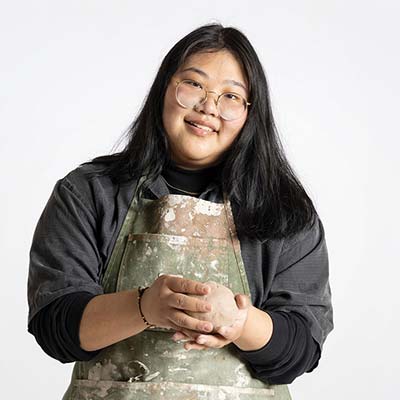 Stephanie poses in front of a blank white wall.