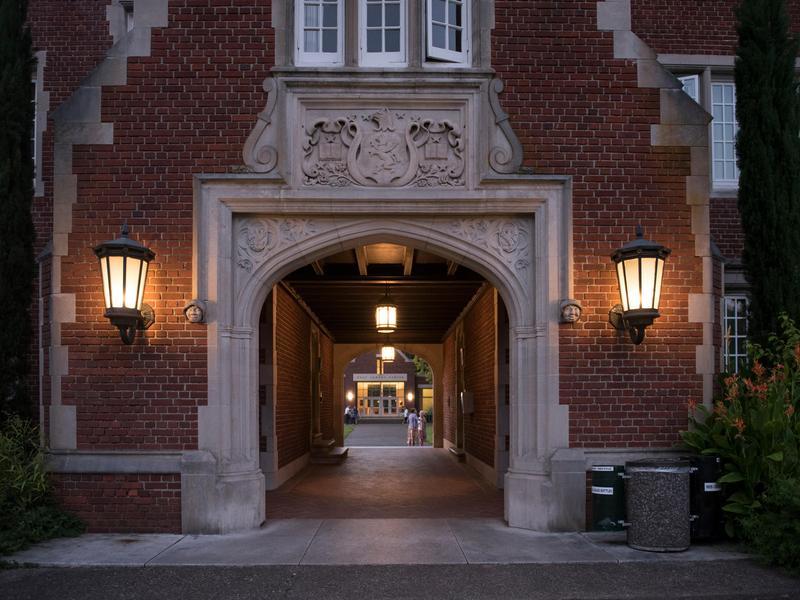 The Old Dorm Block sallyport at night, illuminated on each side by two lamps.