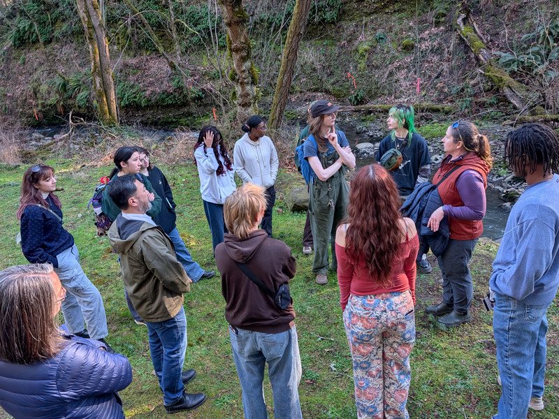 Students and faculty standing near a river