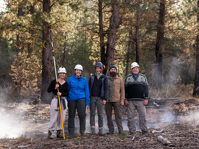 Biology professors David Dalton and Aaron Ramirez, Ariel Patterson ’20, postdoctoral researcher Hannah Prather, and Mahalia Dryak ’20 stand in the charred forest of the Sycan Marsh. Photo by Daniel Cronin.