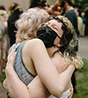 photo of two masked Reed students embracing during the thesis burn