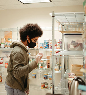 photo of Anthony Hill 22 restocking shelves in the Reed Community Pantry