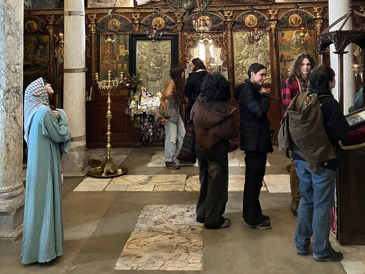 A small group of students look at various displays in a historic Byzantine church.