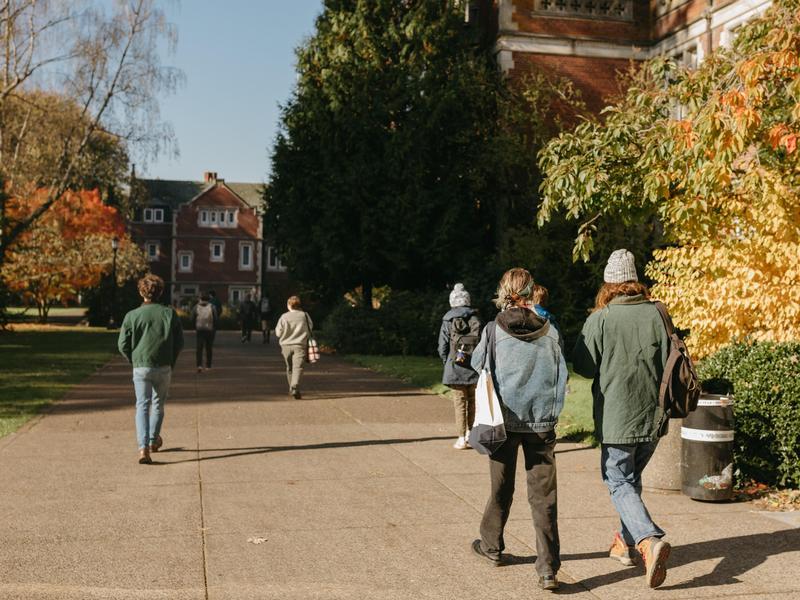 Students walking on campus in front of Eliot Hall.