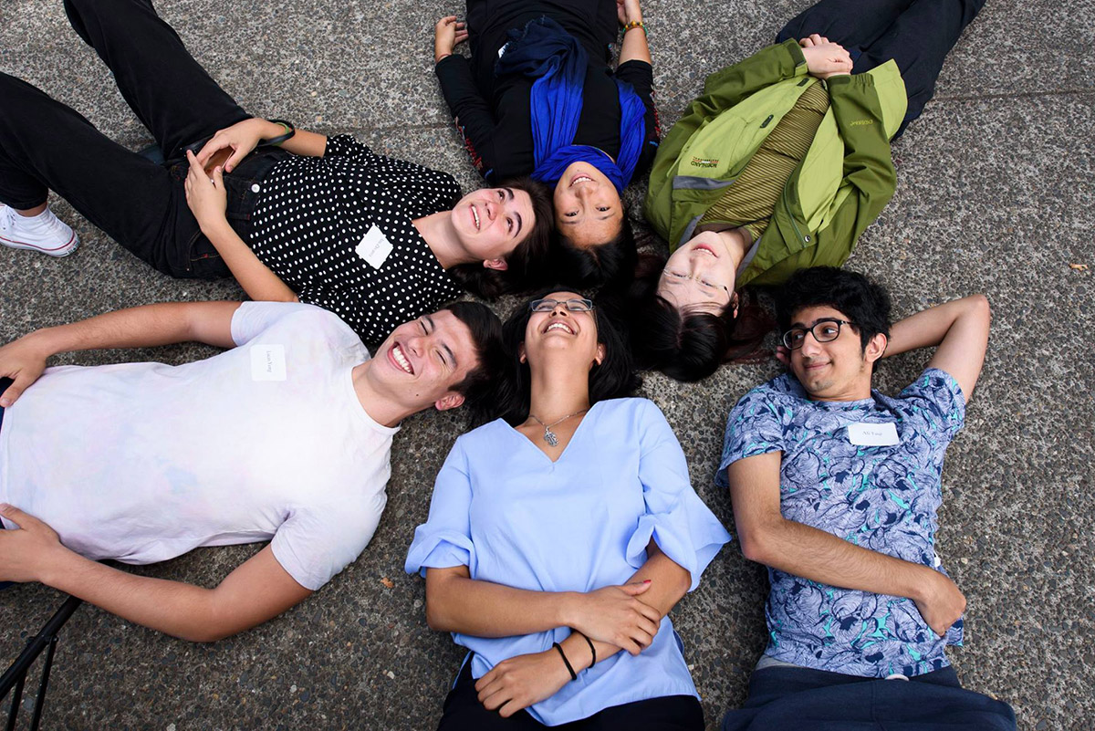 photo of 6 Reed students laying on sidewalk with heads connected