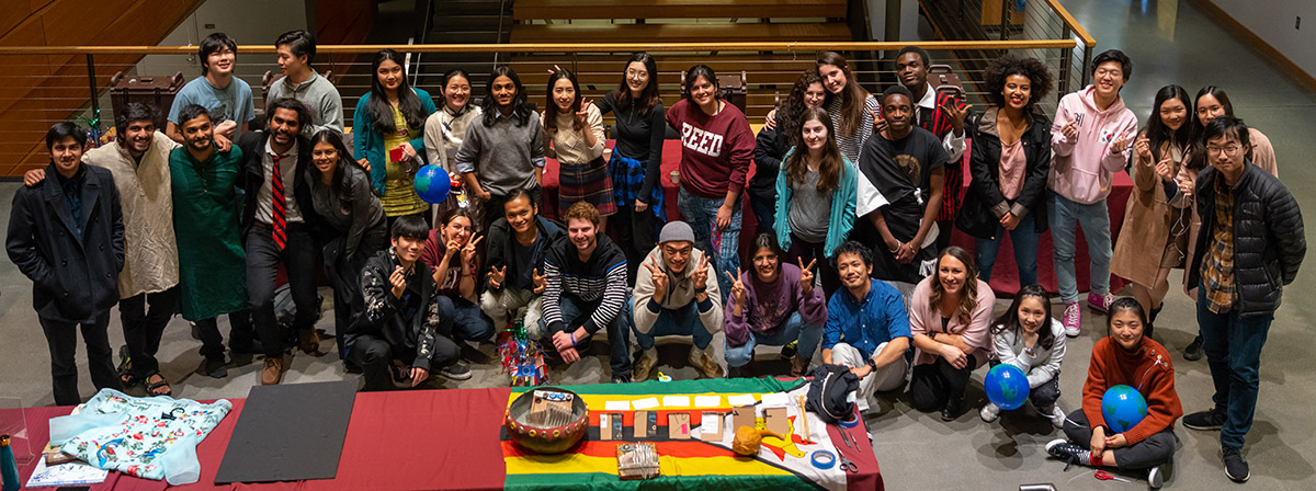 photo of several Reed students gathered in the Performing Arts Building behind a display table