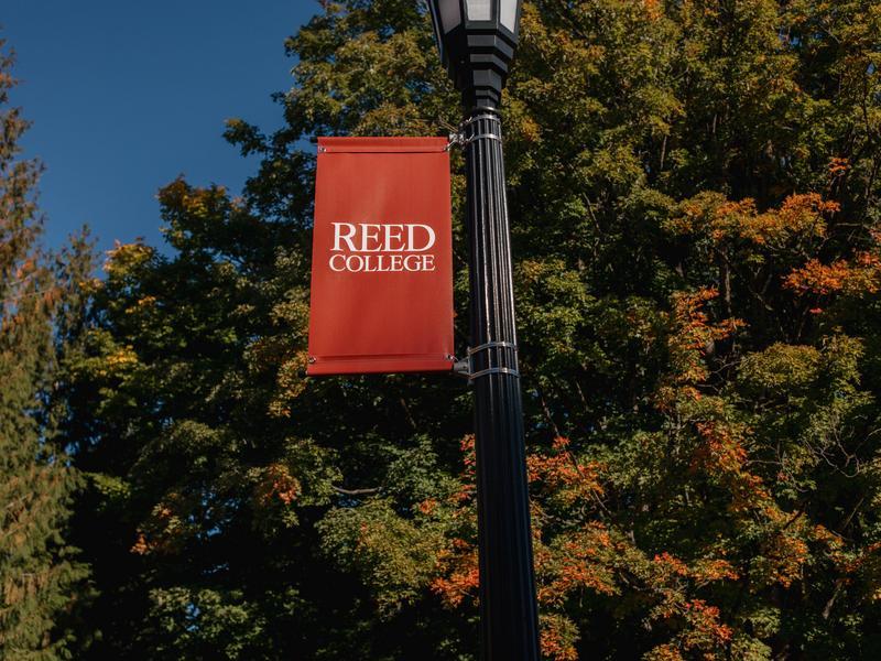 A red banner with white lettering says Reed College and shows an image of a griffin against a backdrop of fall leaves on campus.