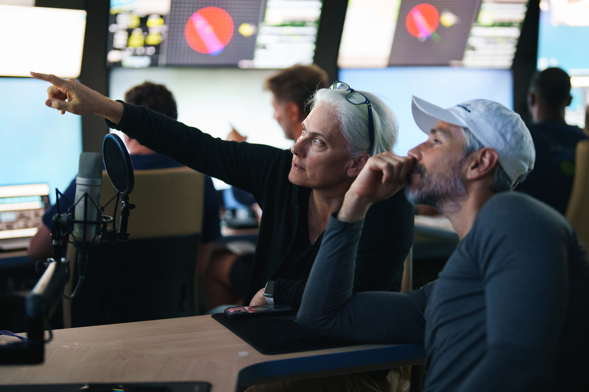 Anitra Ingalls pointing to something out of frame while sitting next to a colleague in a research lab.