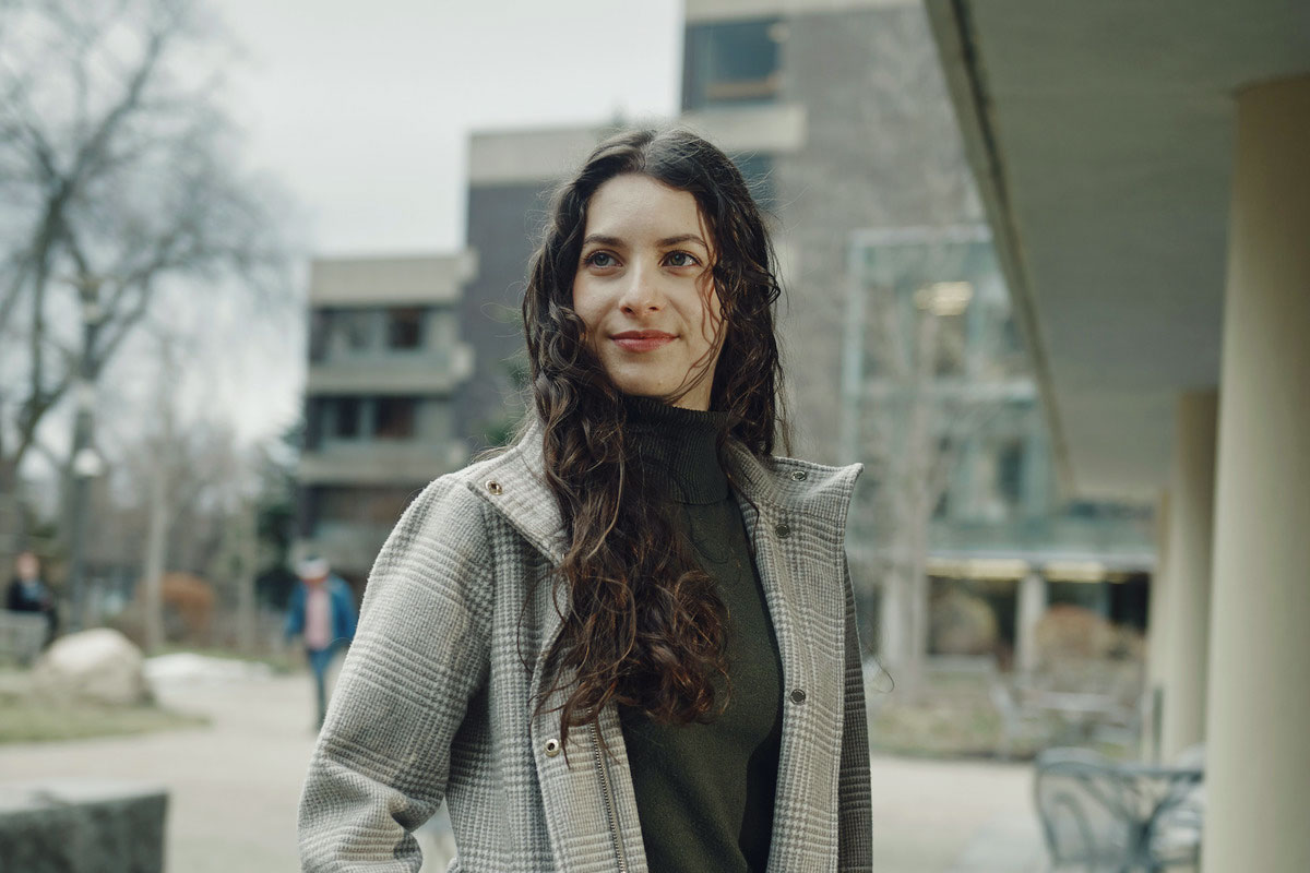 Mariana Beyer standing outside a building and looking off into the distance.