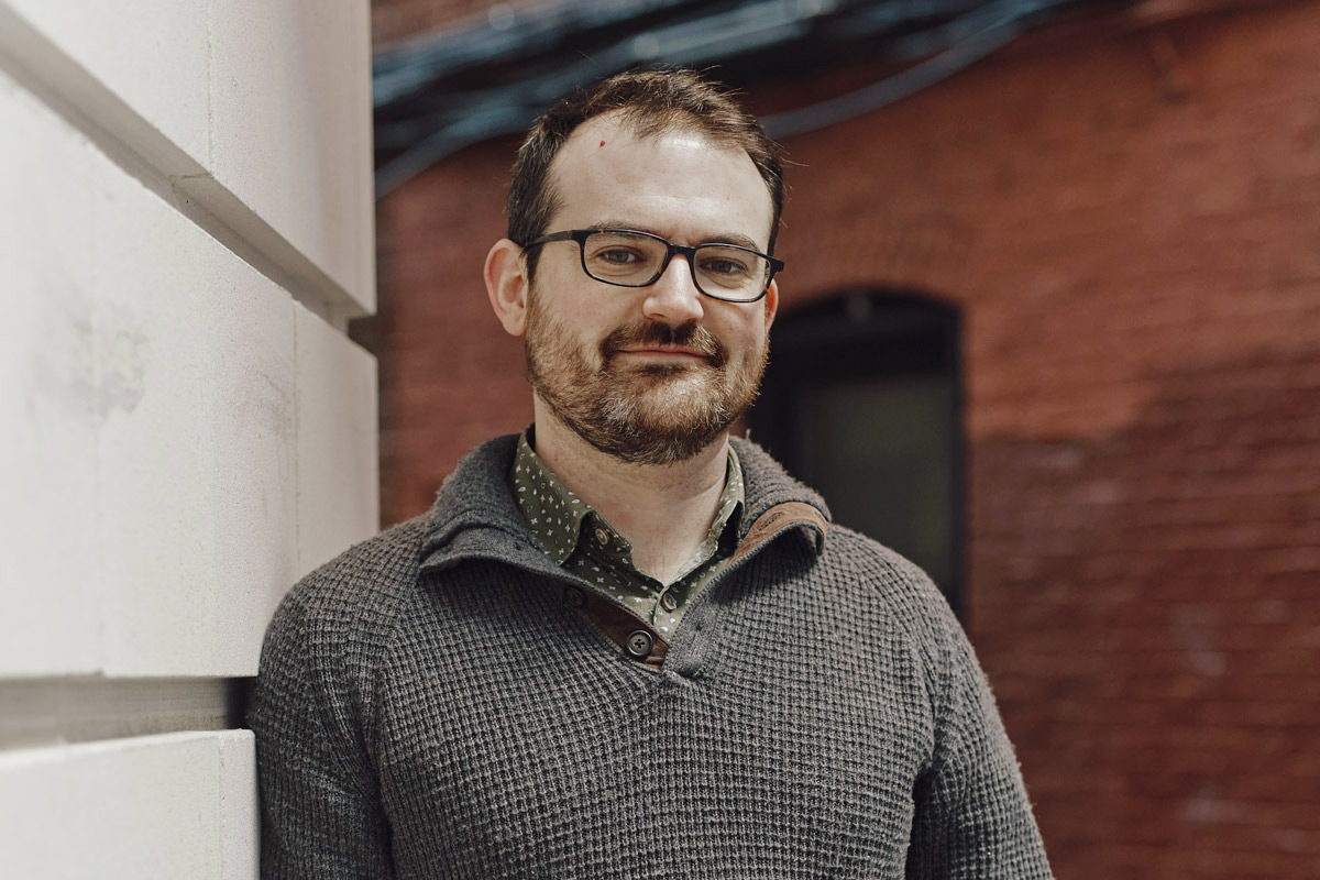Headshot of Nick Pittman standing outside a brick building.