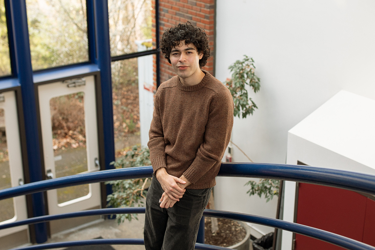 Derrick Santillan Valdez poses for a photo on a spiral staircase.