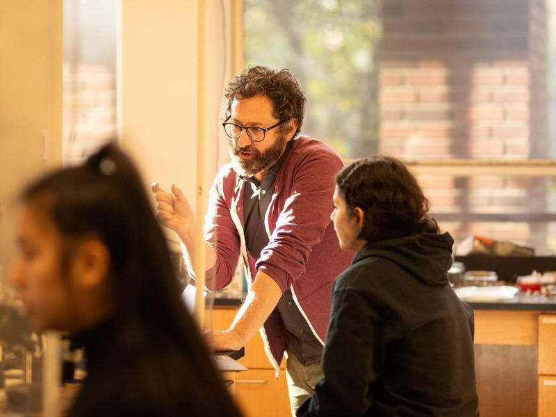 A professor talking to a student in a science lab.