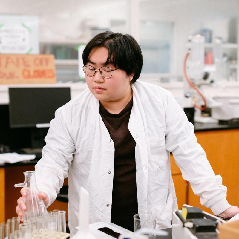 Arthur Tran conducting a scientific experiment in a lab.