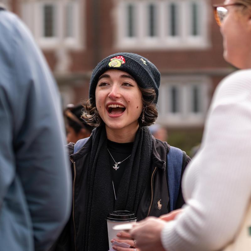 Rowan Soeiro talking to fellow students outside.