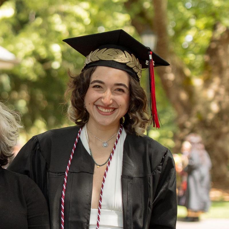 Rowan Soeiro in graduation regalia smiling and posing for photo.