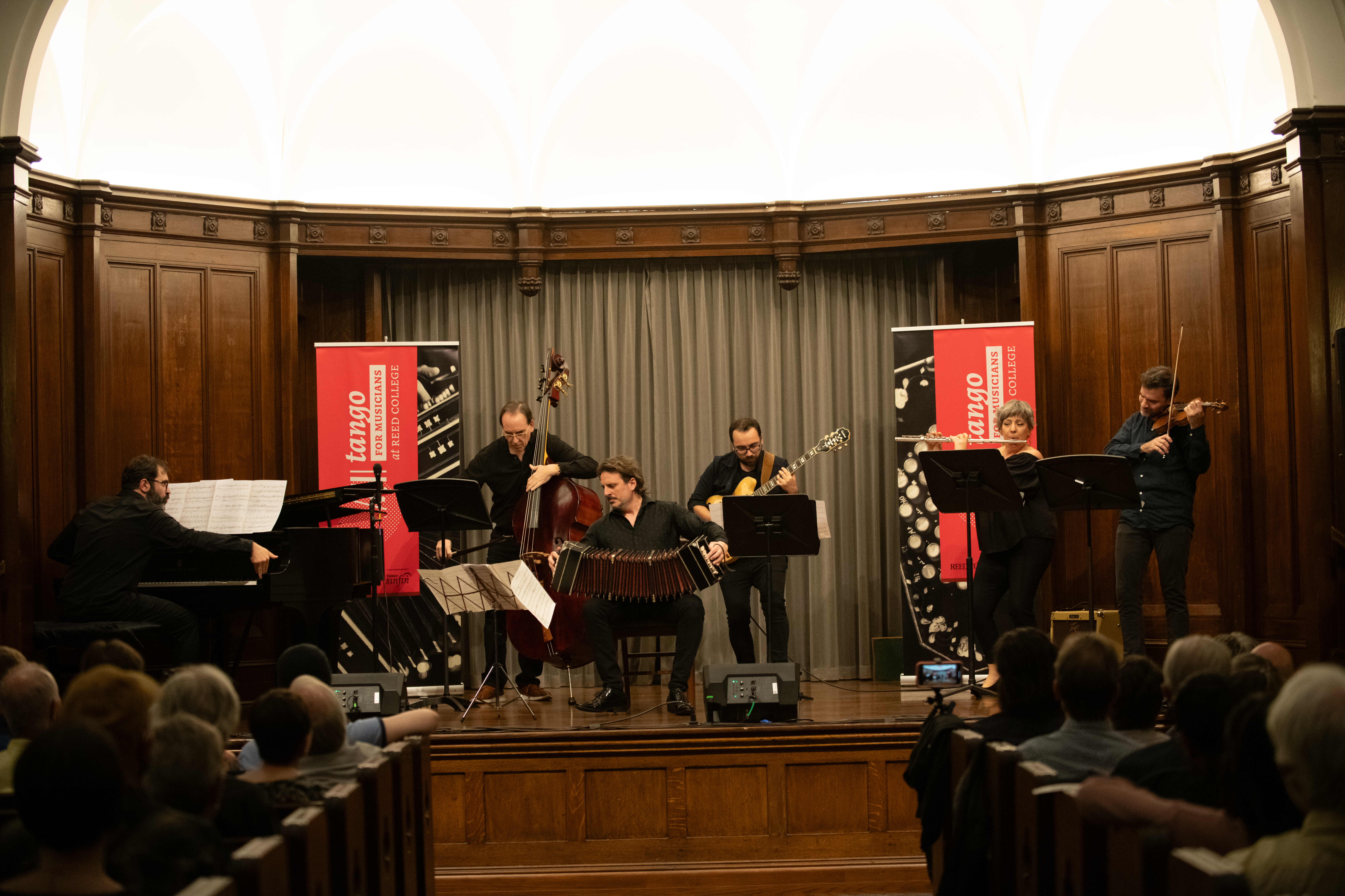Ensemble of six classical musicians performing on a stage