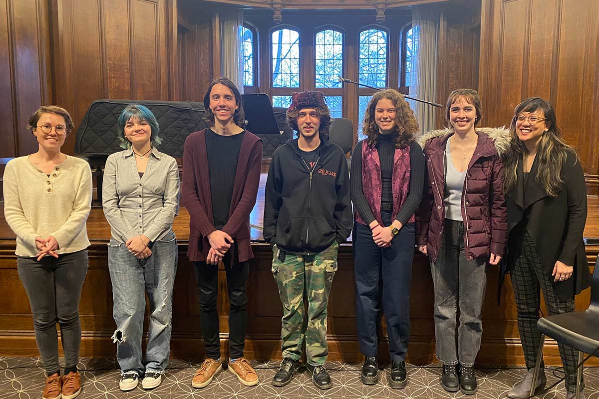 Six music students and their professor stand in front of a stage in Reed's chapel