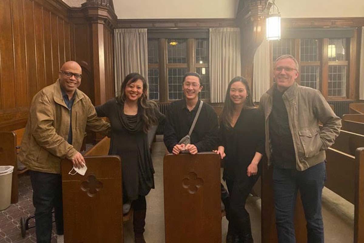Five music faculty and staff pose among the pews of Reed's chapel