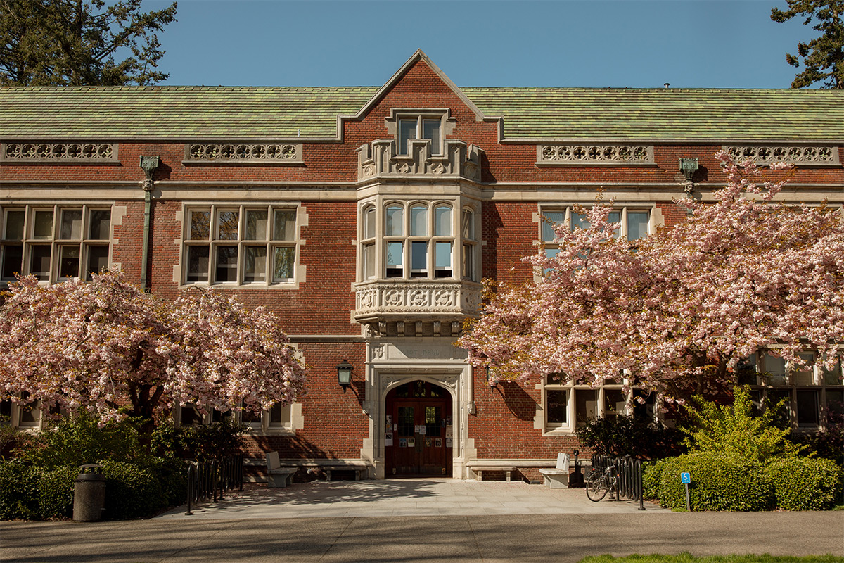 An entrance of Reed College Eliot Hall with pink cherry blossom trees in bloom. 