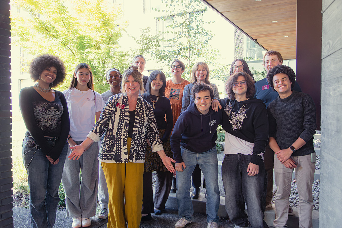 A group of staff and students post together outside on the Reed campus.