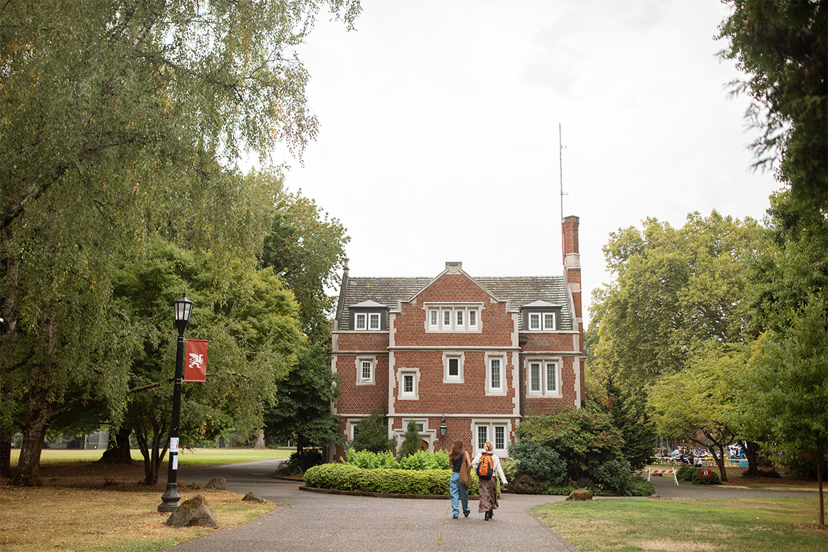 Two students walking on campus on an overcast day. 