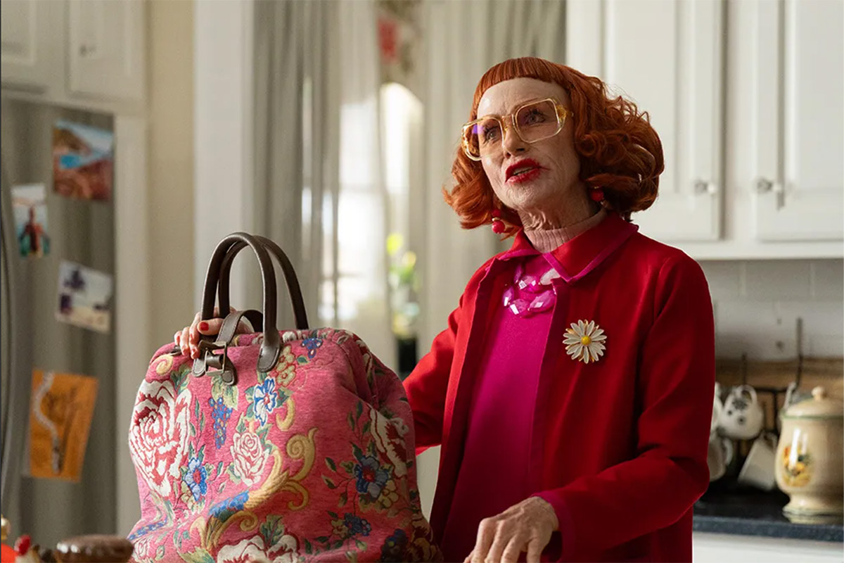 A woman wearing red clothes standing in a kitchen. 