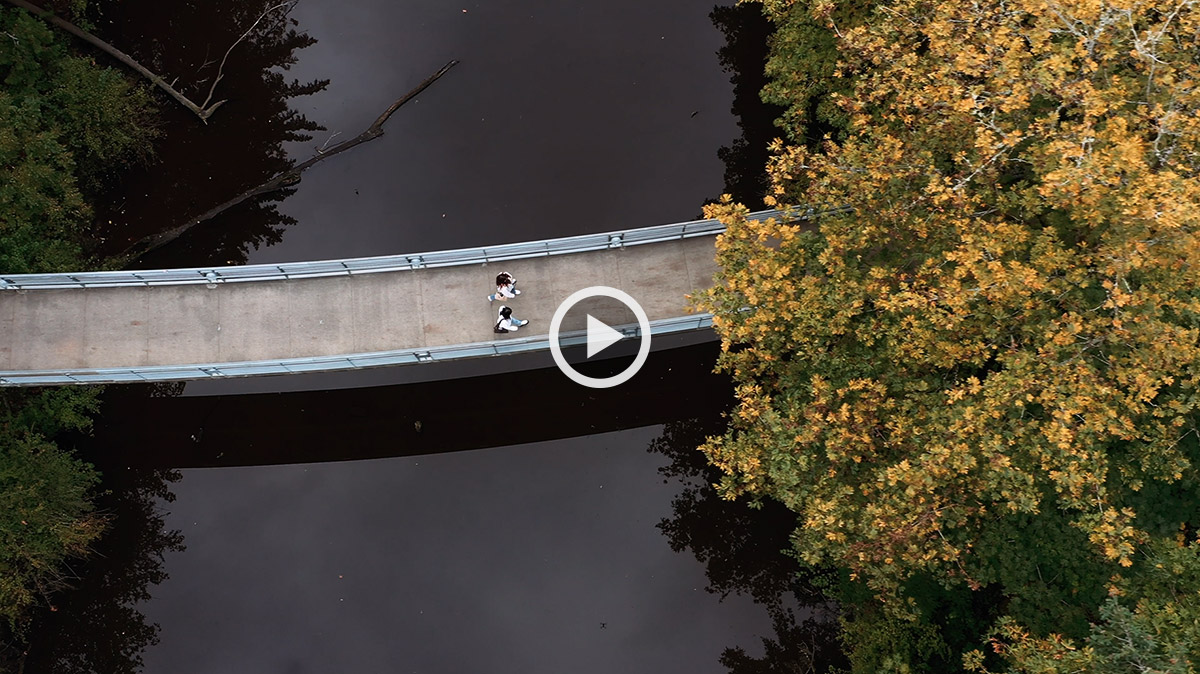aerial photo of two students walking south on the blue bridge over Reed canyon