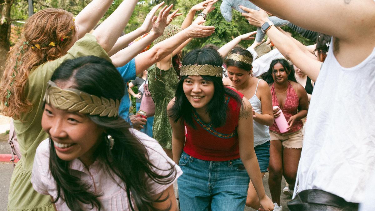 Reed seniors running through a tunnel formed by fellow students at the end of the annual Thesis Parade.