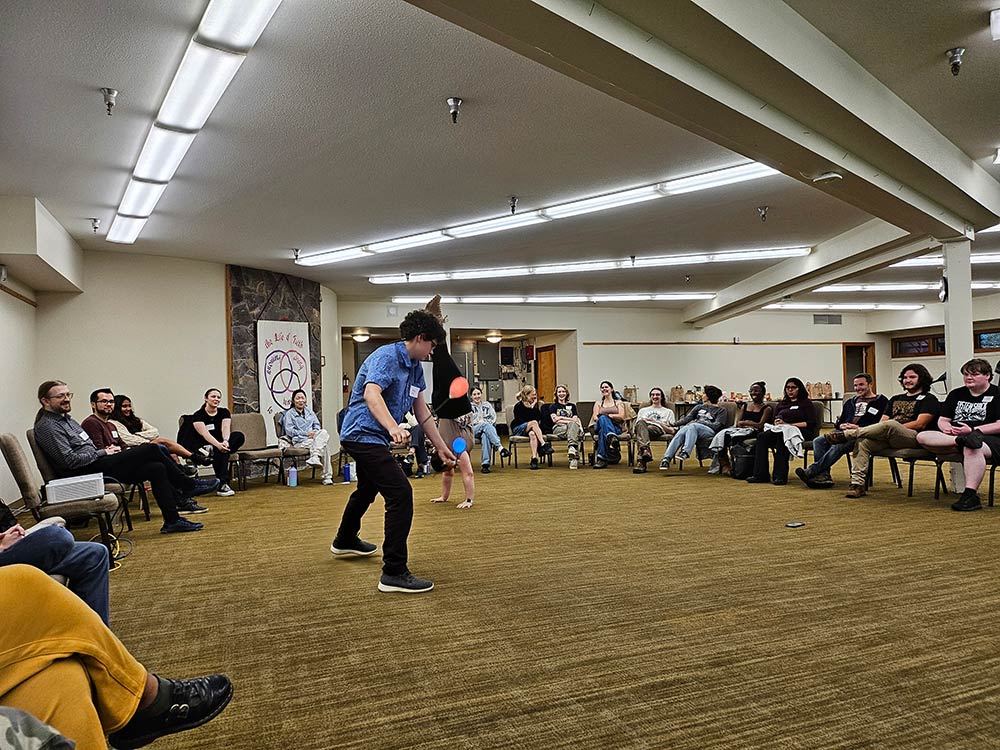 Two students performing cartwheels in a circle of many other students