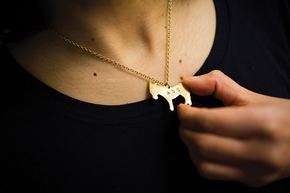 golden donkey shaped necklace that reads Ass
