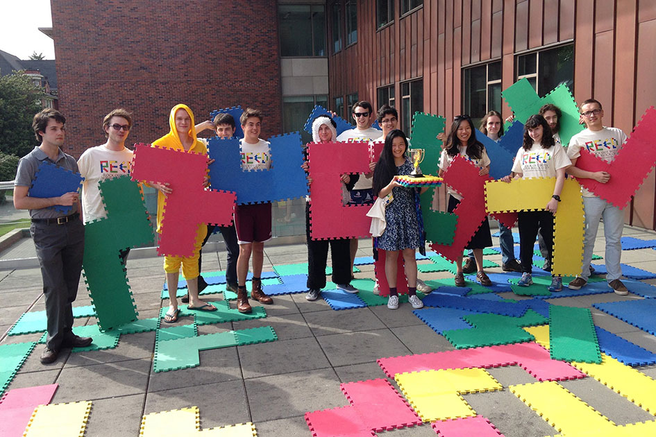 Triumphant Reed students brandish gamepieces after taking first place in the Pacific Northwest Intercollegiate Ginormous Blokus Tournament.