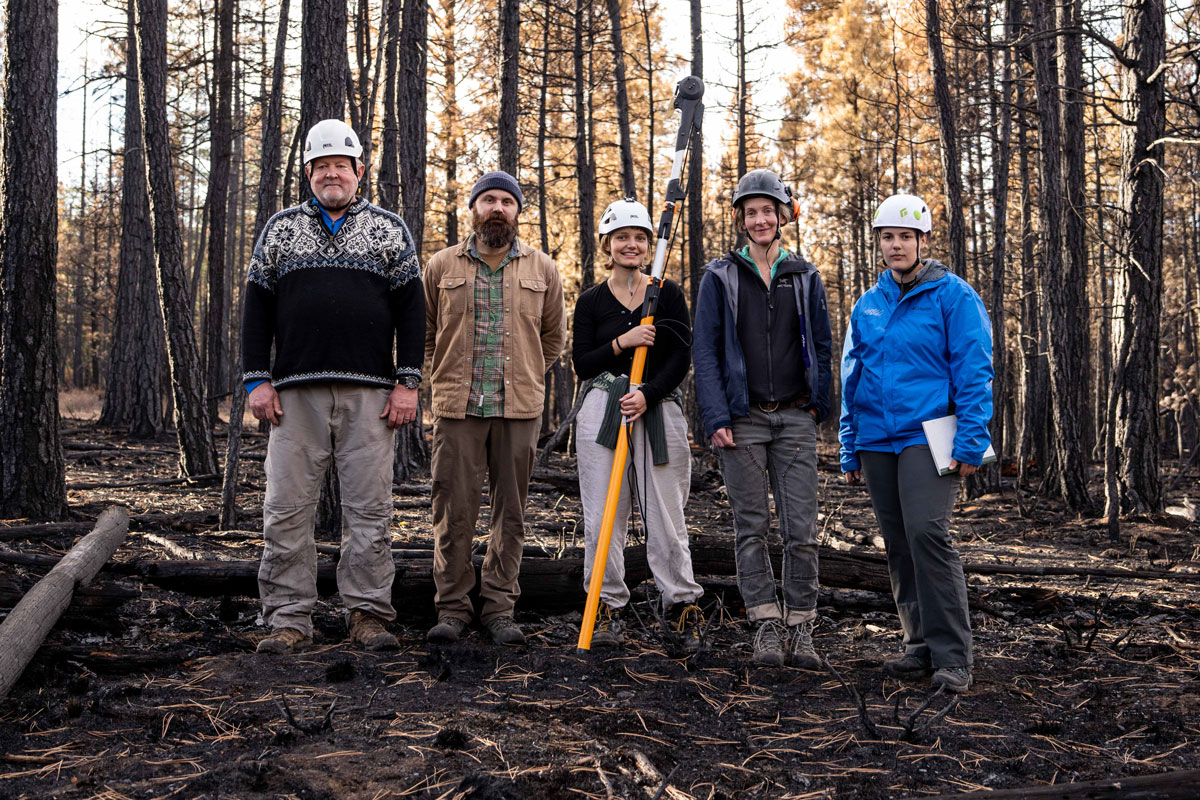 Biology professors David Dalton and Aaron Ramirez, Ariel Patterson ’20, postdoctoral researcher Hannah Prather, and  Mahalia Dryak ’20 stand in the charred forest of the Sycan Marsh.