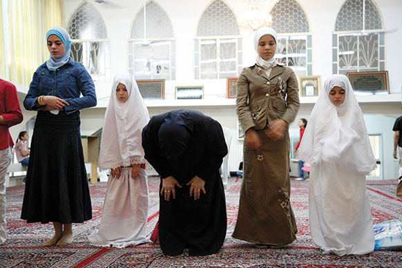 Houda (center) praying with her students at Al-Zahra Mosque, Damascus, from&amp;#160;The Light in Her Eyes.&amp;#160;
