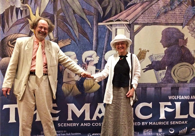 Photo of John and Judith Cushing holding hands in front of a poster