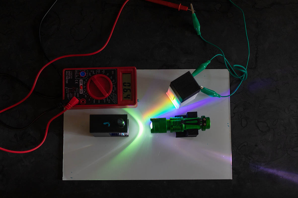 A DIY spectrophotometer on a table shining a prismatic rainbow