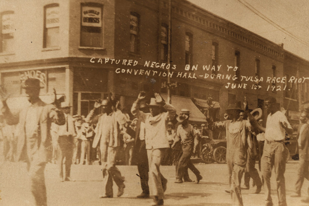 a group of black men marching with their hands up